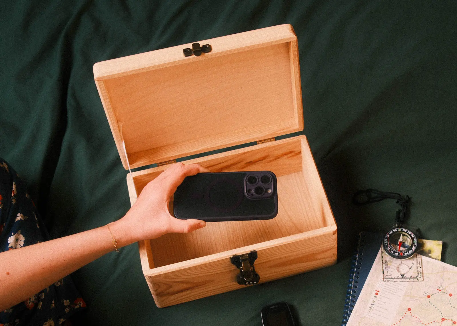 Handen die een houten box openen om een smartphone op te bergen